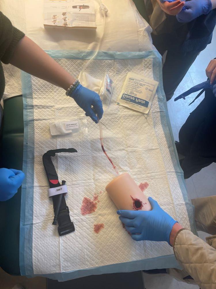 Students using wound simulator in intro to med career class