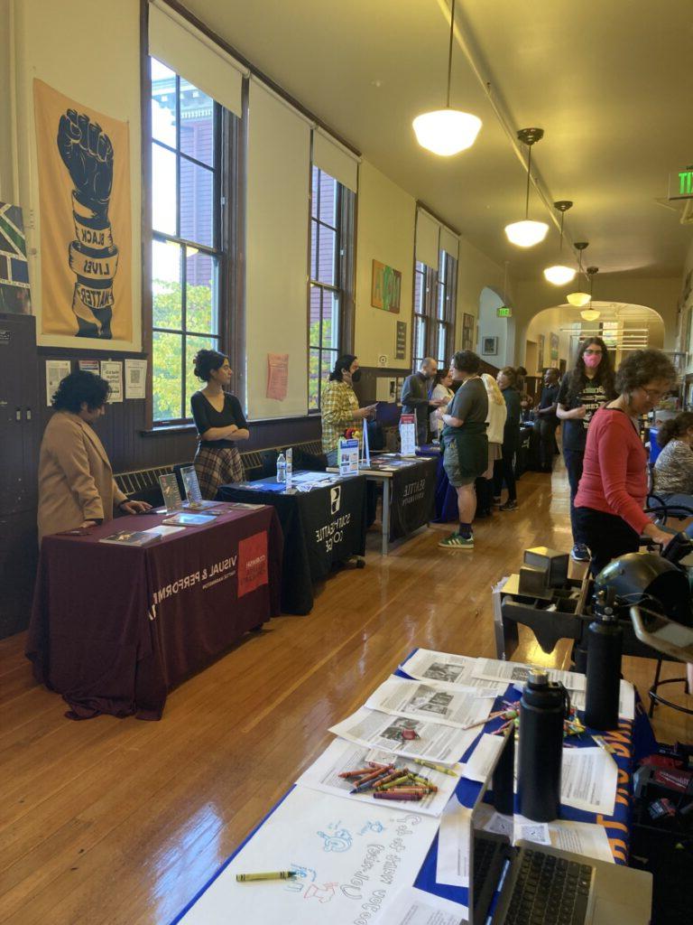 Tables lining hallway of high school with colleges representatives