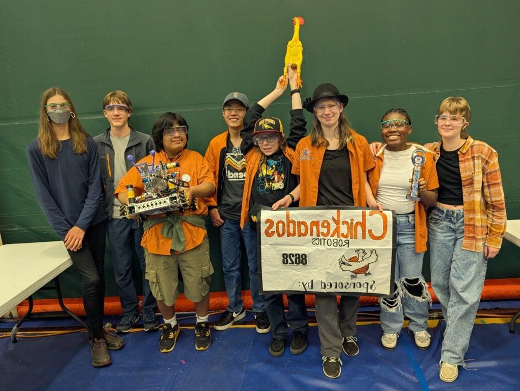 Students in front of homemade sign reading "Chickenados Robotics"